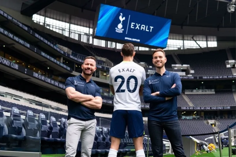The EXALT team at Tottenham Hotspur Stadium, beside a player in an EXALT shirt